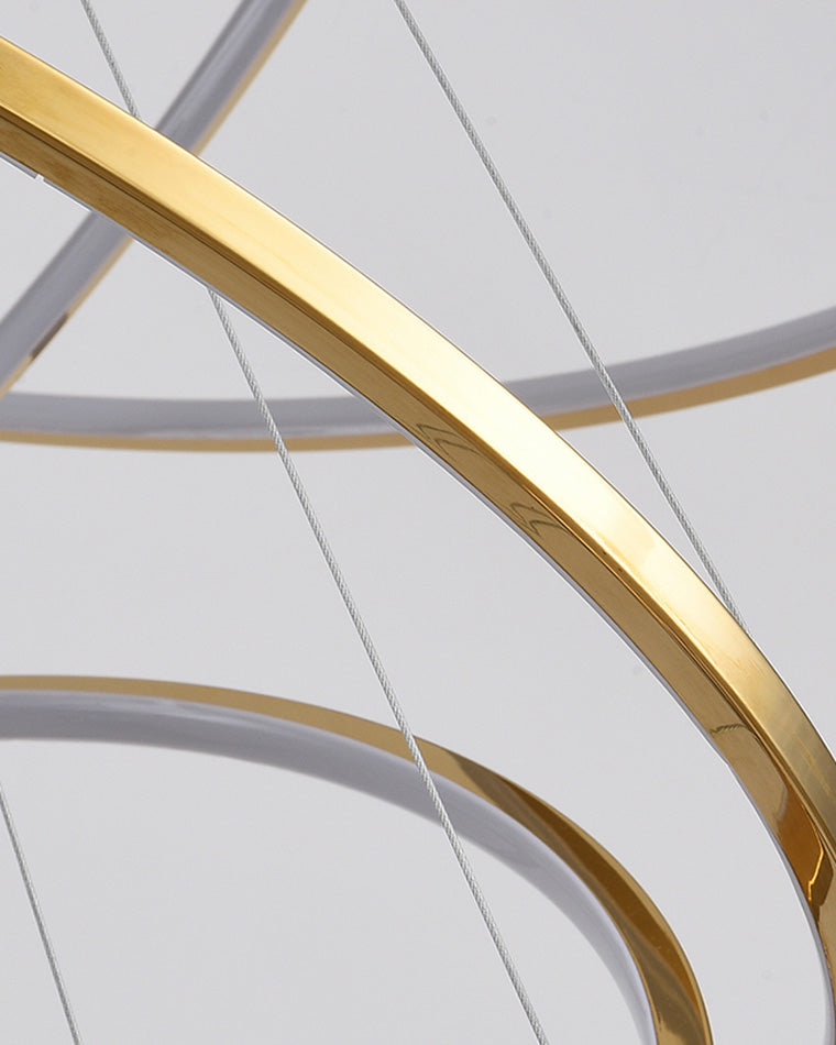 Close-up of the polished gold stainless-steel ring and fine suspension cables, highlighting the chandelier’s precise, refined construction.