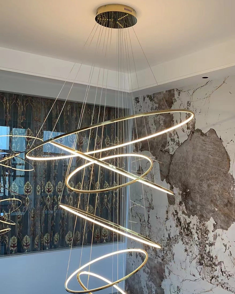 Side view of cascading LED rings, revealing the polished canopy, fine suspension system and dynamic asymmetrical arrangement.