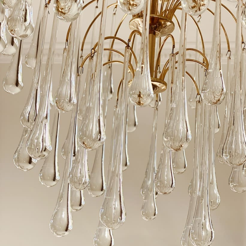 Close-up of a chandelier with clear glass drops and gold metalwork.