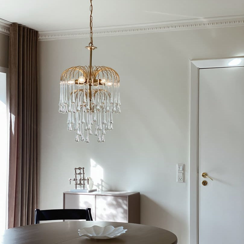 Chandelier hanging above a dining table in a room with neutral decor.