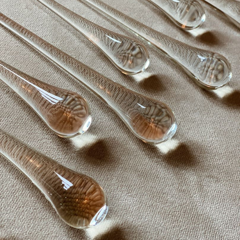 Set of clear glass droppers on a beige fabric background