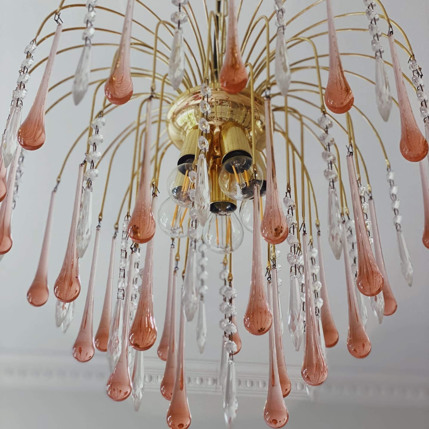 Decorative chandelier with pink and clear glass droplets on a white ceiling.