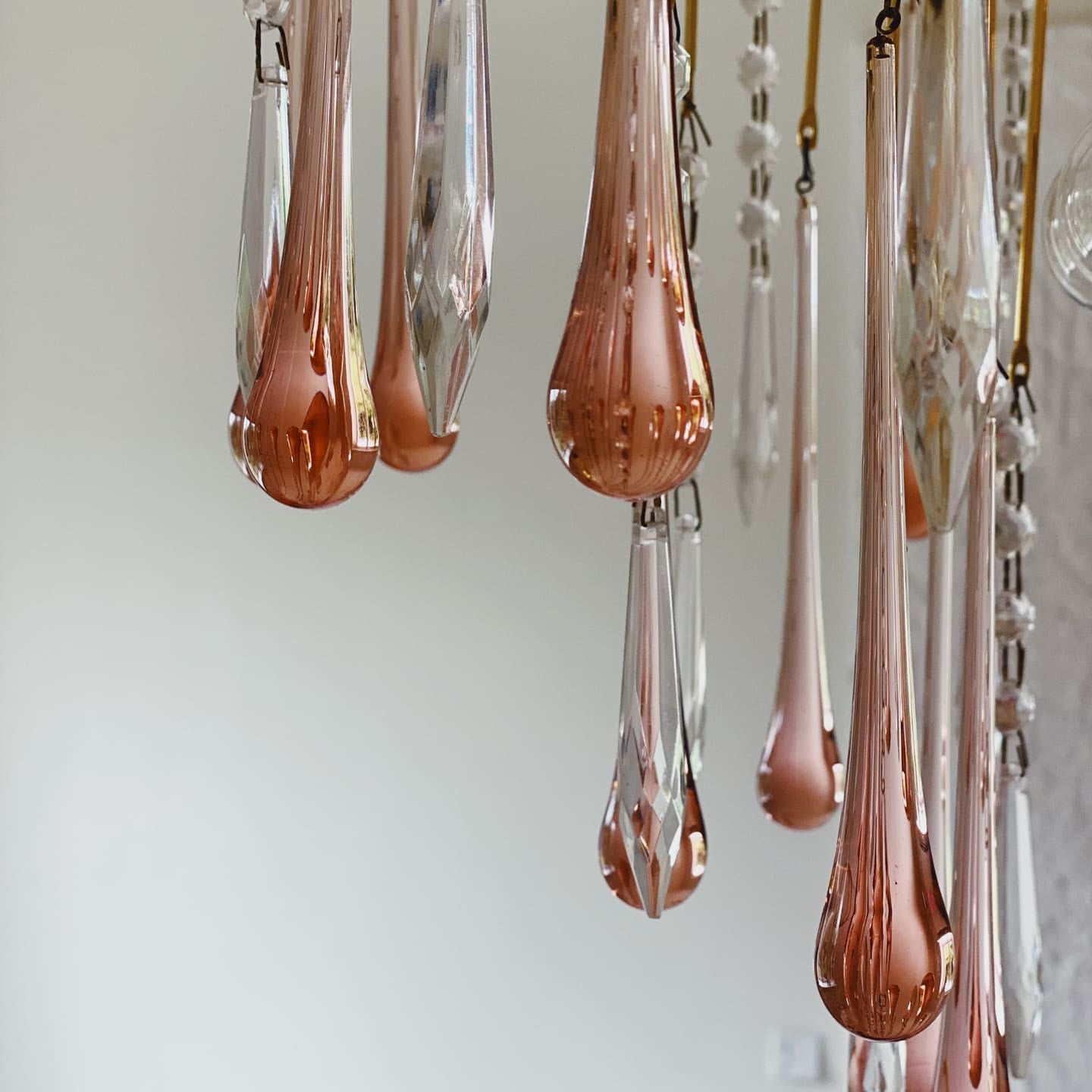 Rose gold teardrop-shaped chandelier against a white background