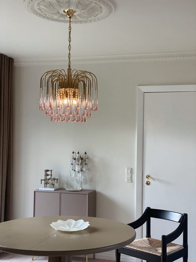 Dining room with a chandelier, table, and chairs.