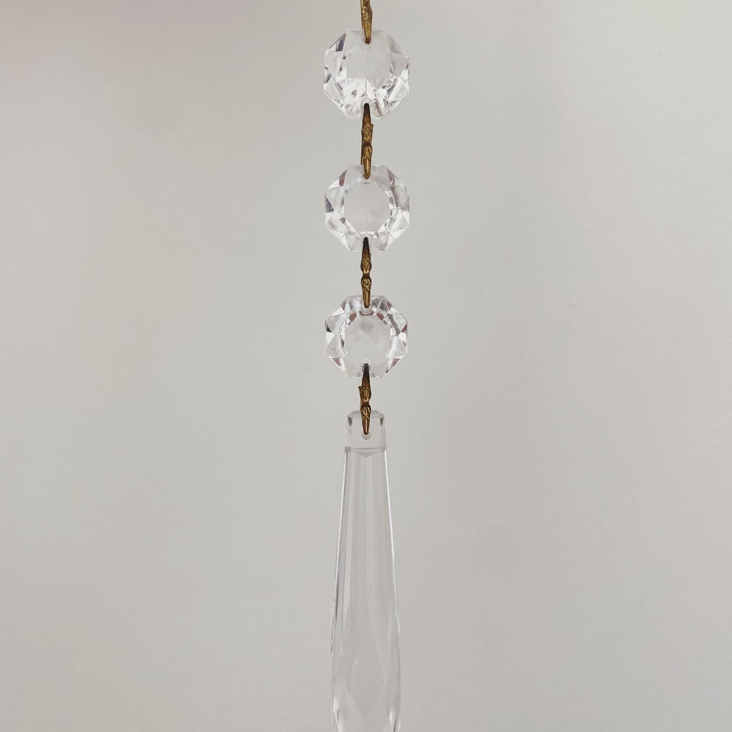 Crystal hanging decoration with teardrop shape on a plain background