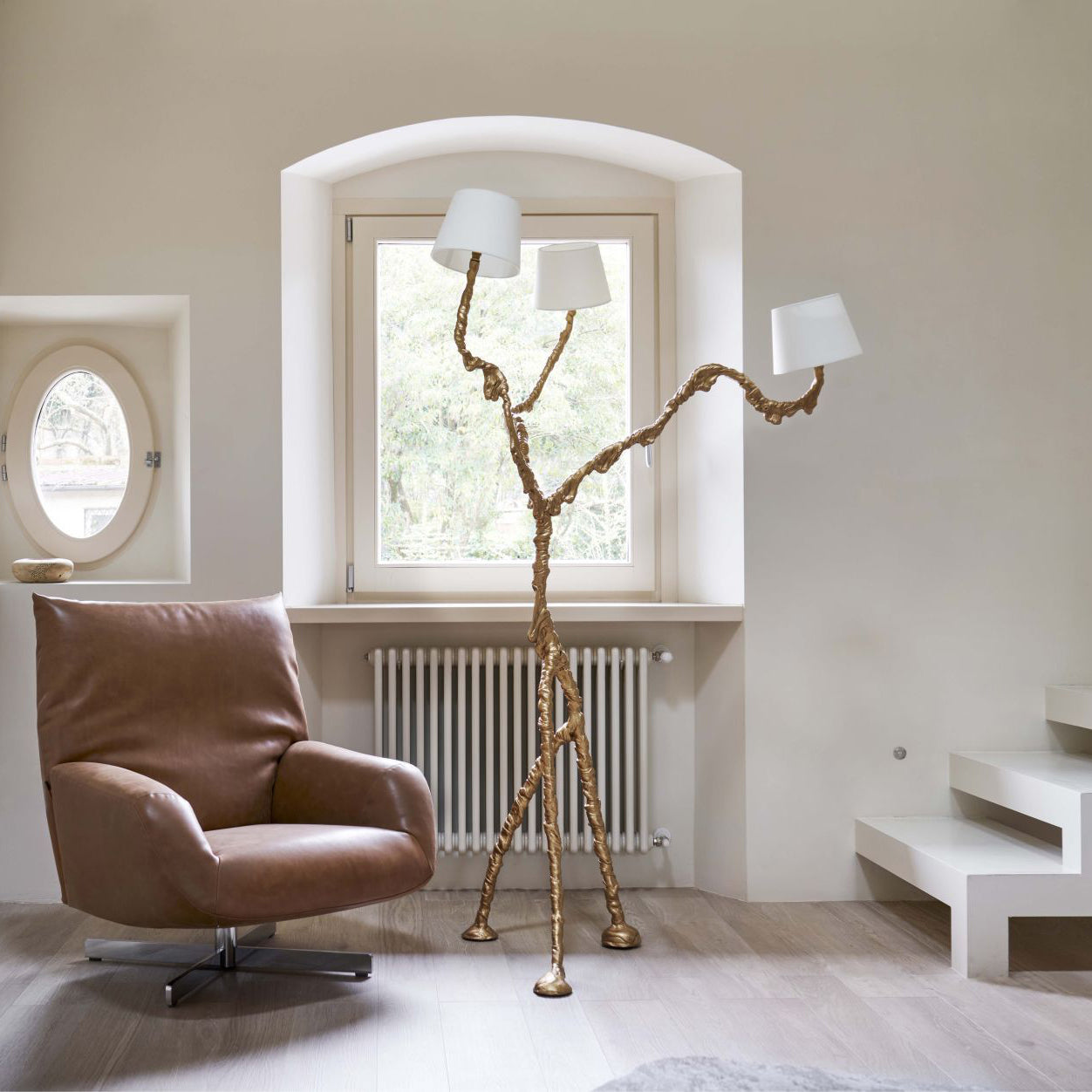 Full view of tall brass branch floor lamp with three white shades