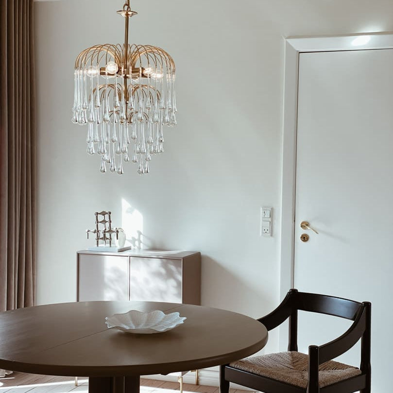 Dining room with a round table, chair, and decorative chandelier.