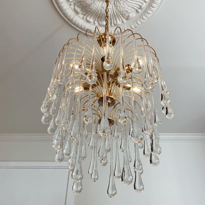Decorative chandelier with crystal elements hanging from a ceiling.