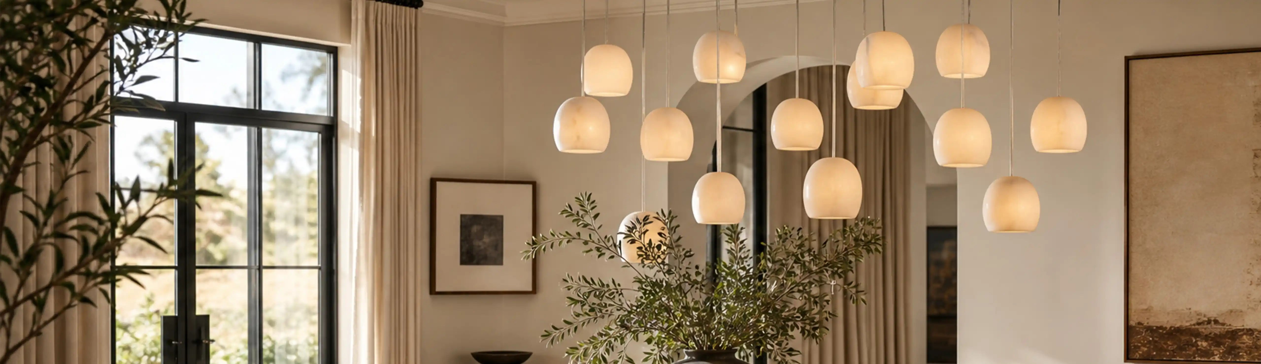 Cluster of softly glowing rounded pendants beside tall windows in a neutral interior