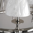 Close-up of a decorative lamp with a white pleated shade and metallic base.