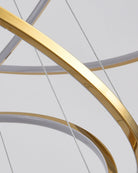 Close-up of the polished gold stainless-steel ring and fine suspension cables, highlighting the chandelier’s precise, refined construction.