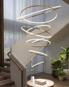 Warm entryway chandelier illuminating a double-height stairwell, drawing the eye upward while softening the emptiness of the open void.