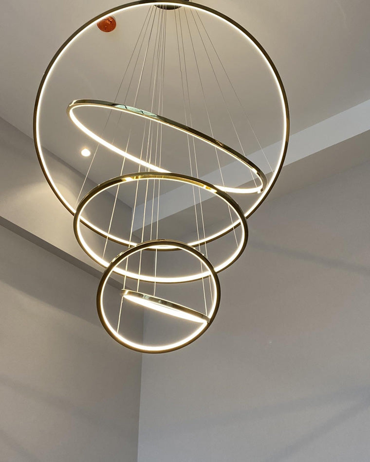 Compact four-ring chandelier configuration delivering sculptural warm light where a full-length cascade would overwhelm the ceiling height.
