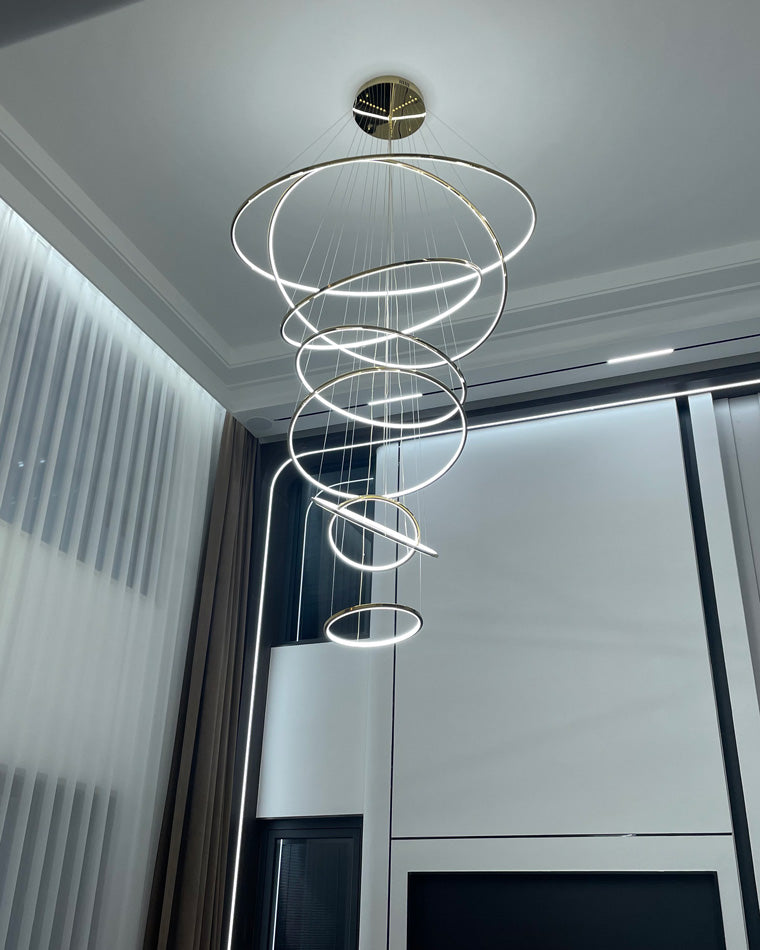 Cool-white LED ring cascade brightening a modern high-ceiling room, delivering a cleaner, more architectural nighttime atmosphere.