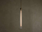 Front view of a modern brass and clear glass pendant light fixture with a long, illuminated filament bulb inside.