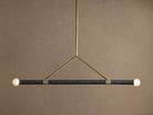 Randall Leather Pendant: Dark leather-wrapped horizontal bar with two frosted globe bulbs, suspended by a burnished brass frame.