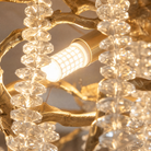 A Blush gold metal branch chandelier with cascading crystal beads suspended in a rainfall arrangement.