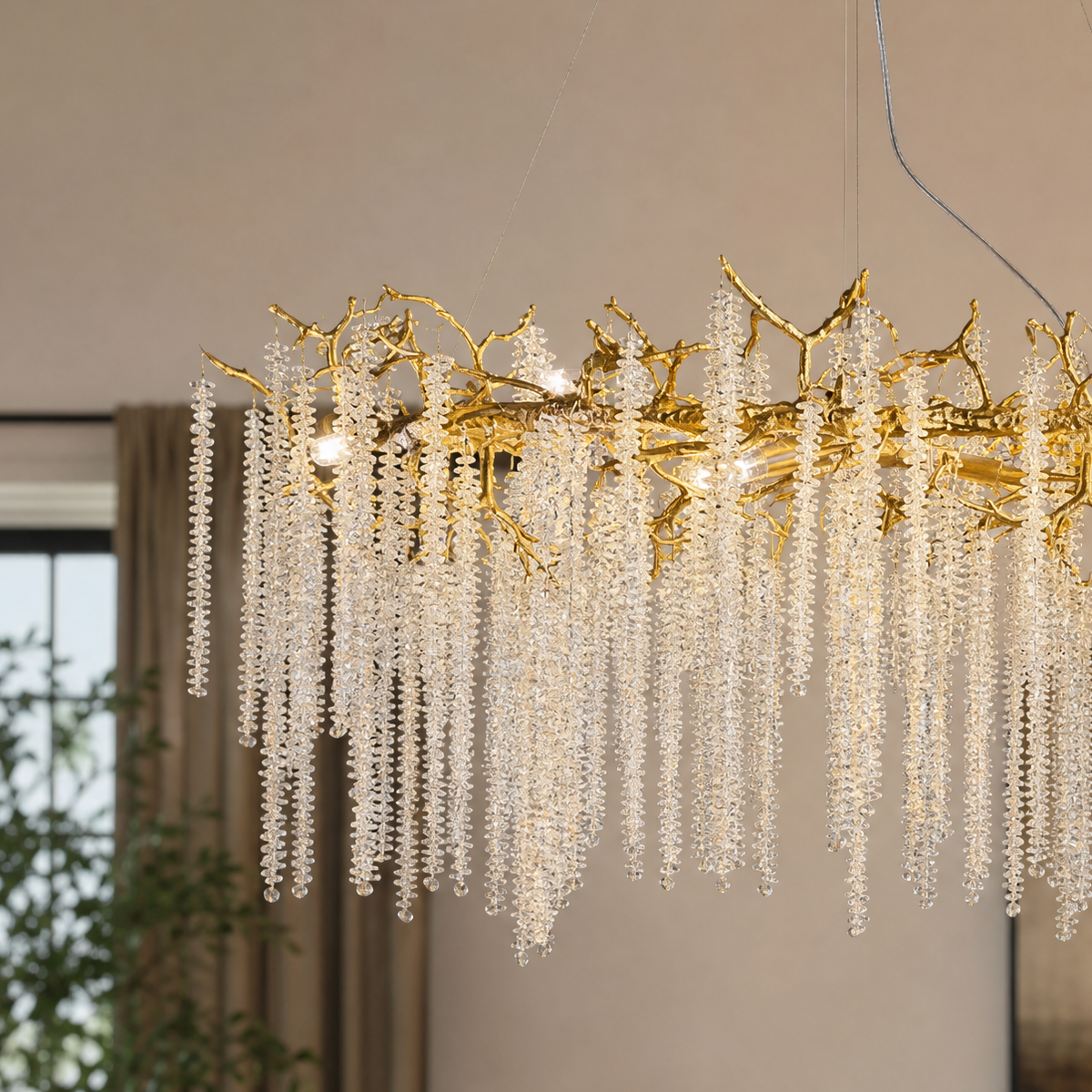 A Blush gold metal branch chandelier with cascading crystal beads suspended in a rainfall arrangement.