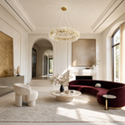 A circular gold metal chandelier with frosted glass leaf accents suspended by thin cables.