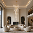 A tiered gold chandelier featuring cascading clear crystal icicle pendants suspended from a metallic branch-like frame.