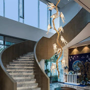 Bird Glass Branch Long Chandelier For Staircase is made of handmade brass and Bird shape glass. The brass frame is inspired by the surface of the organic tree, with the glass bird on the tree. Perfect for your Staircase.