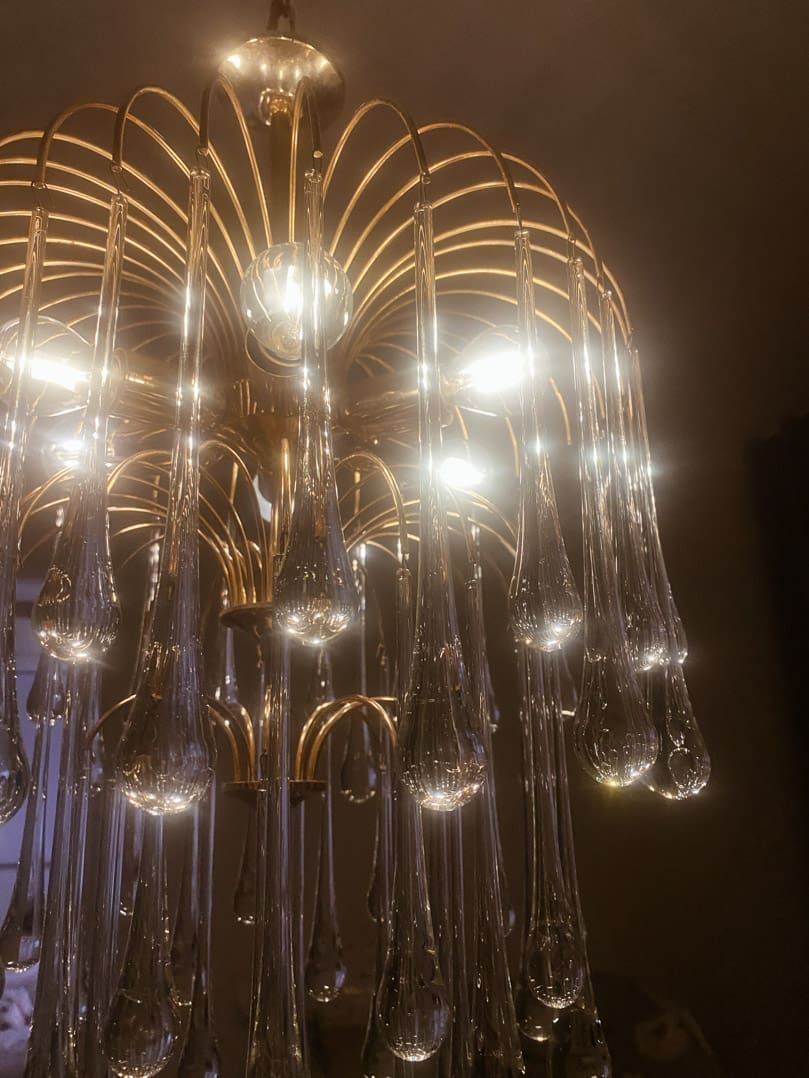 Gold chandelier with glass droplets against a dark background