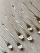 Set of metallic teardrop-shaped objects on a beige fabric background