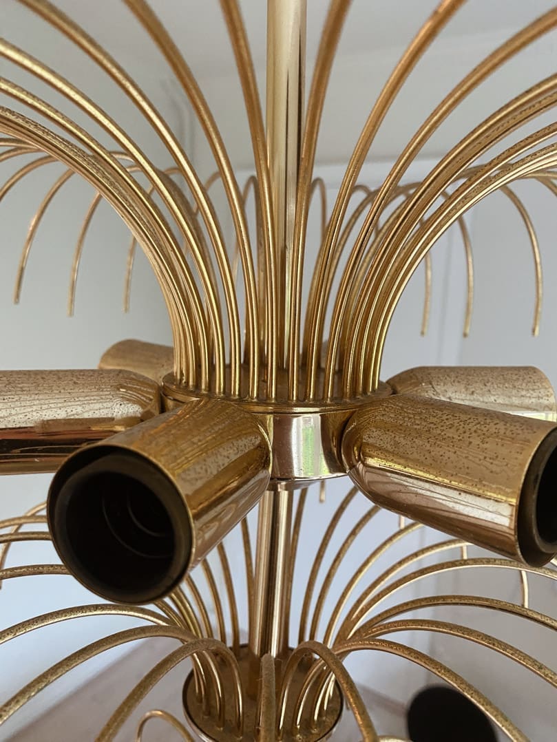 Close-up of a gold chandelier with multiple arms.