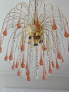 Decorative chandelier with pink and clear glass droplets on a white ceiling.