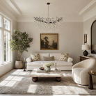 A modern matte black metal branch chandelier adorned with cascading clear crystal drops in a circular shape.