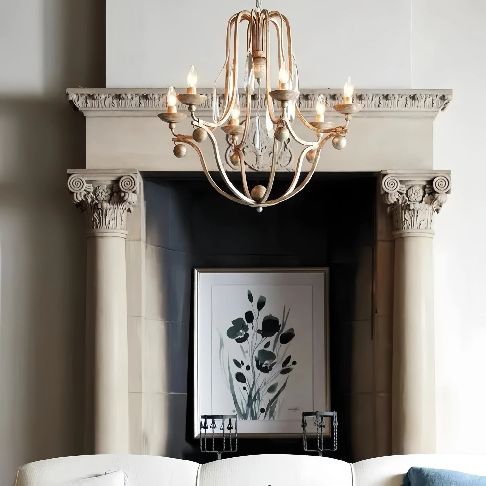 bonita chandelier silver hanging above a fireplace with a framed picture of flowers on the mantel.